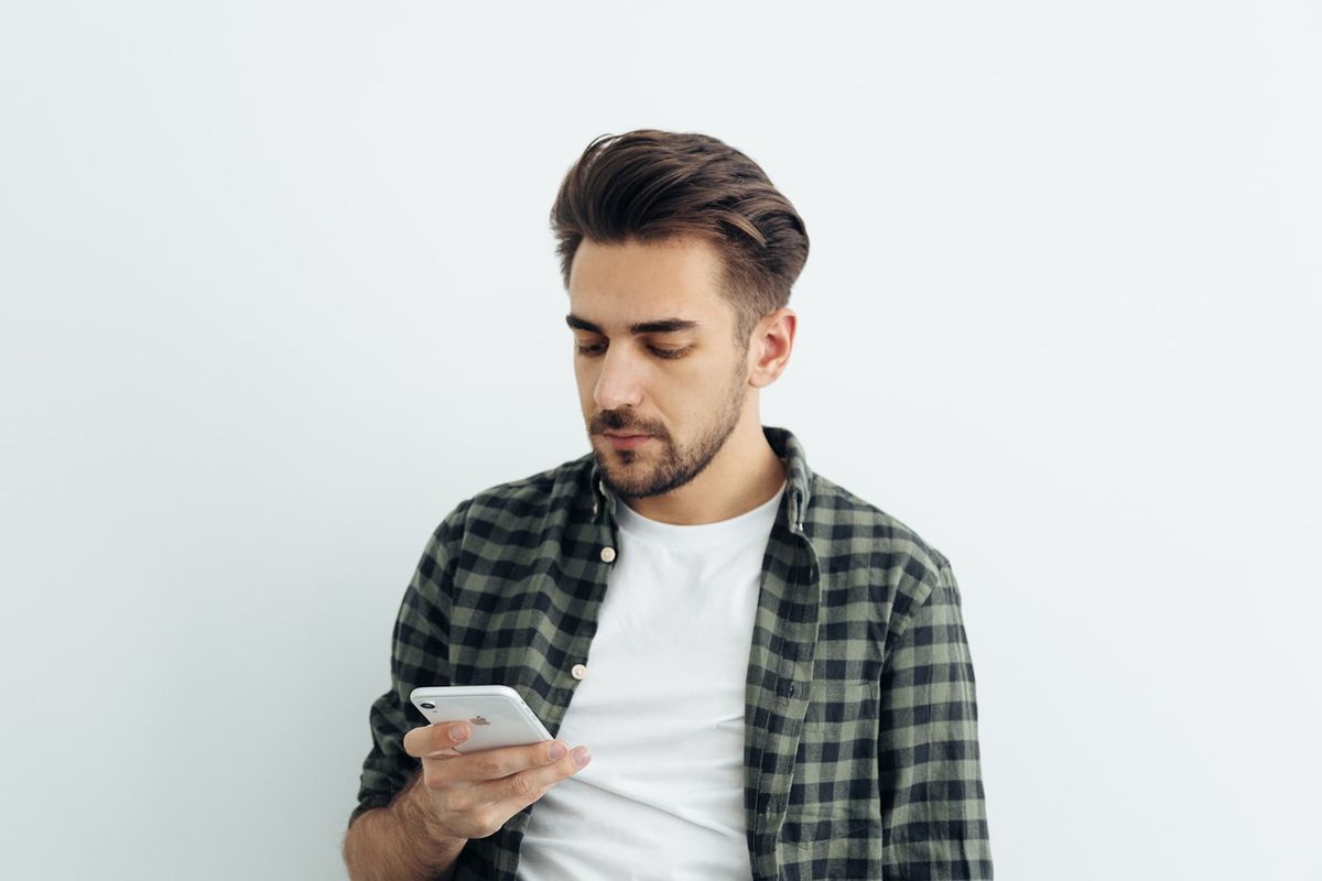 Bekymret person kigger på sin smartphone