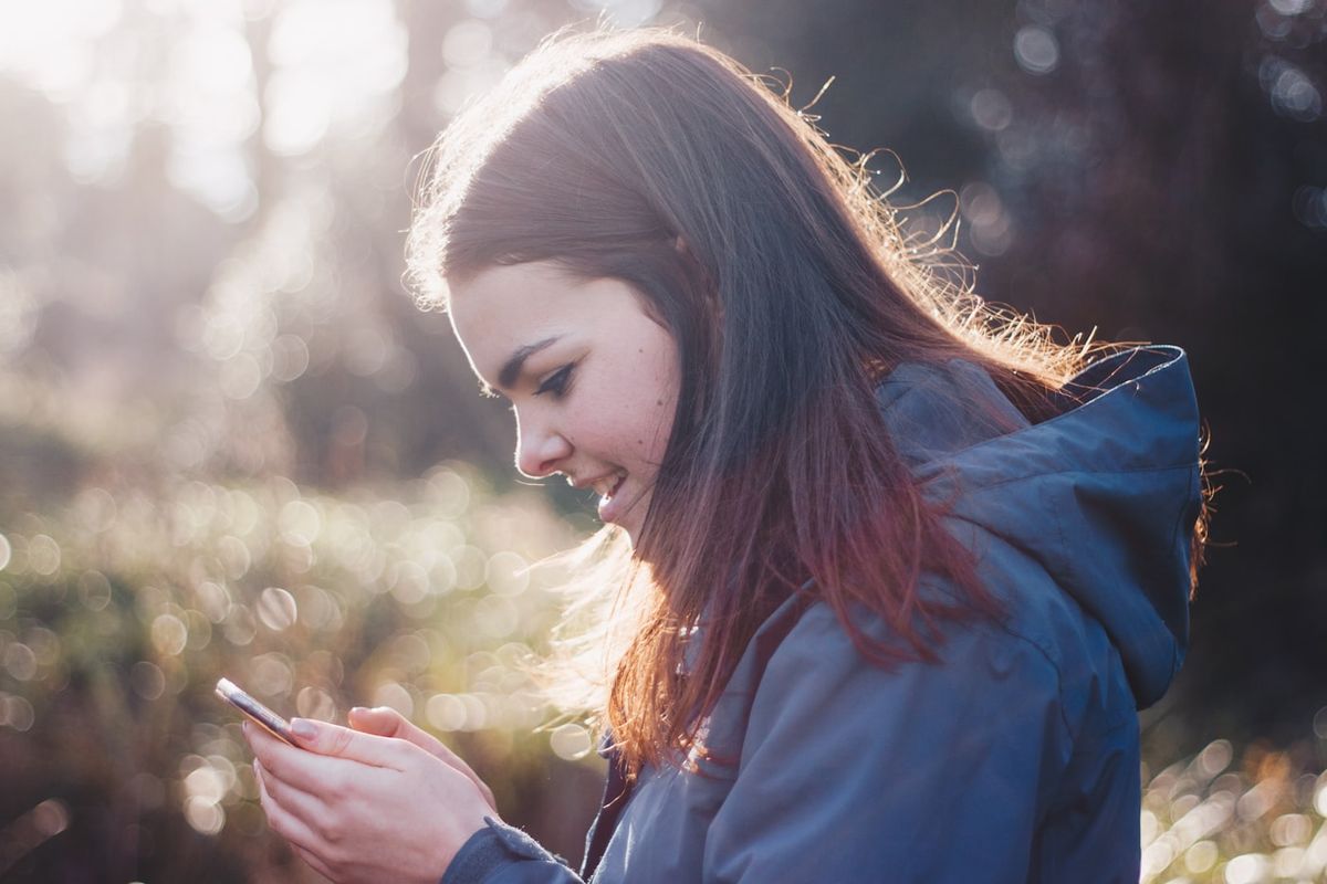Ung person bruger en smartphone udendørs