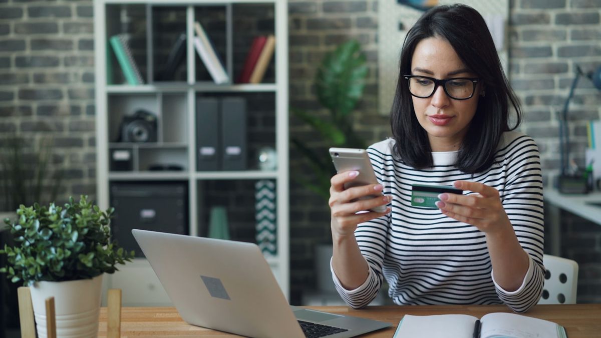 Person betaler regning online via smartphone og computer