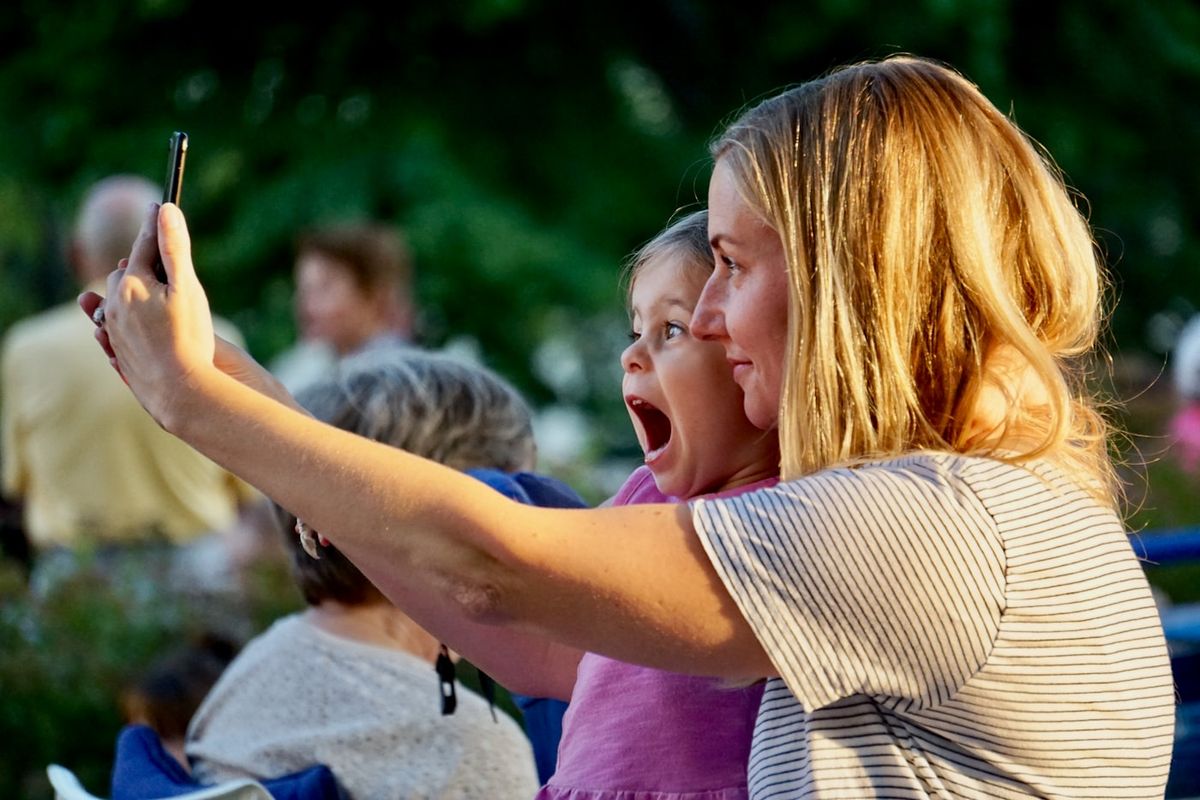 Mor og barn tager en selfie udendørs i sollys